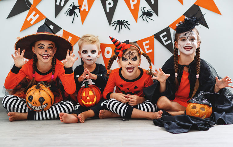 happy Halloween! a group of children in suits and with pumpkins in the home happy Halloween! a group of children in suits and with pumpkins in the home