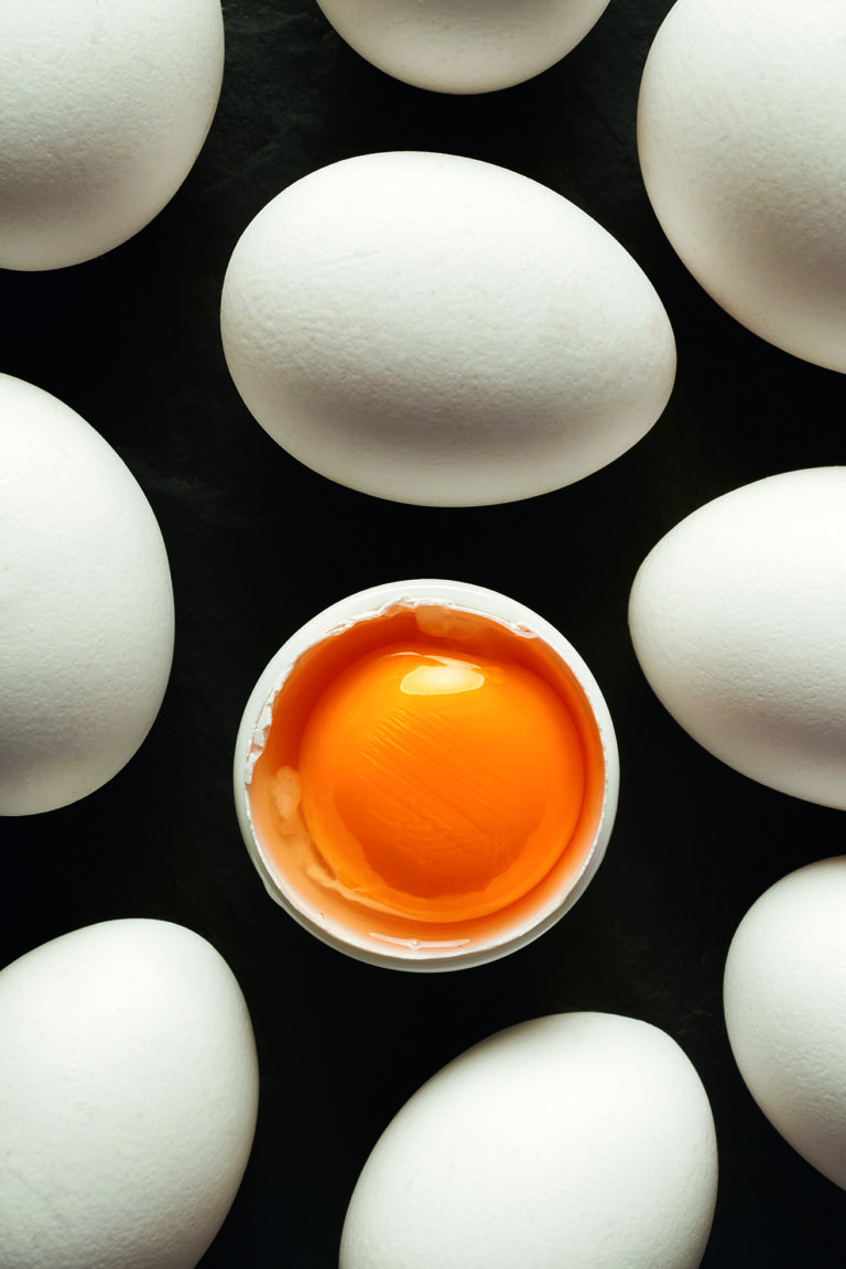 Chicken eggs with white shells on a black background. Black and white concept Chicken eggs with white shells on a black background. Black and white concept