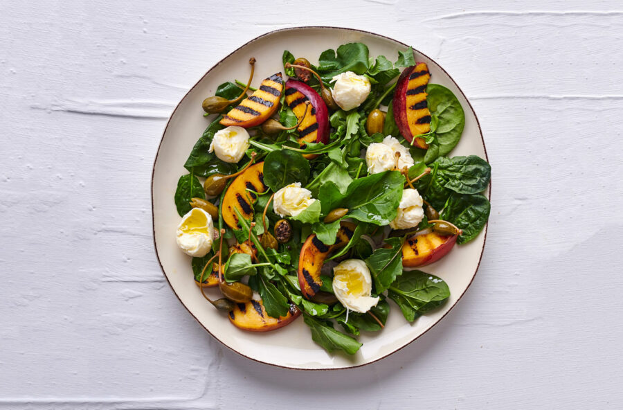 Insalata con pesche grigliate, bocconcini di mozzarella e frutti di cappero