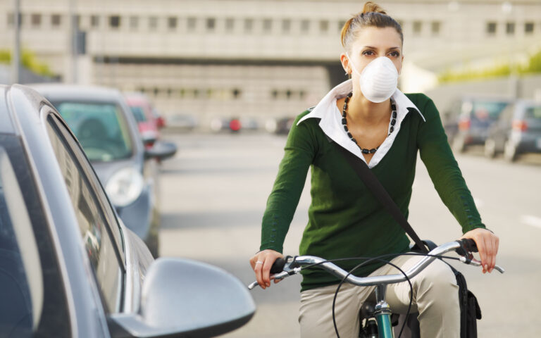 woman with dust mask commuting on bicycle