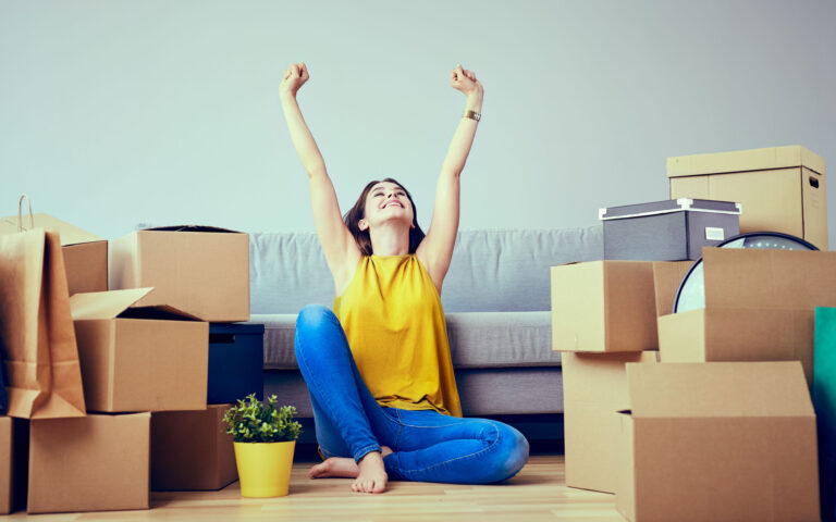 Happy young woman moving to new home - having fun