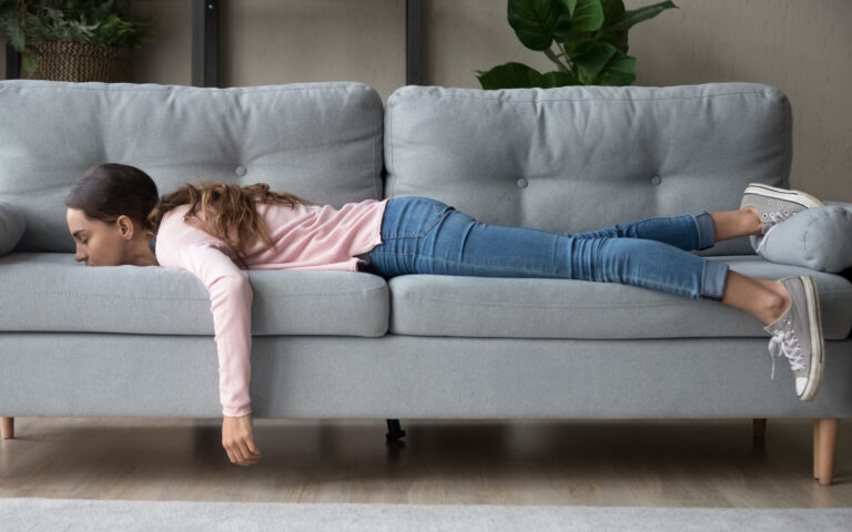 Full length of girl lying rest at home in living room buried her face in couch feels exhaustion having day nap lack of energy after party sleepless night or overworked, too tired no motivation concept