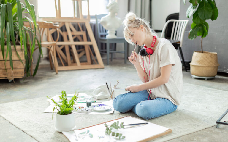 Portrait of outstanding blonde girl trying to sketch green and young sprout on paper. Gorgeous female holding pencil in order to draw precious picture. Arts and crafts concept Portrait of outstanding blonde girl trying to sketch green and young sprout on paper. Gorgeous female holding pencil in order to draw precious picture. Arts and crafts concept