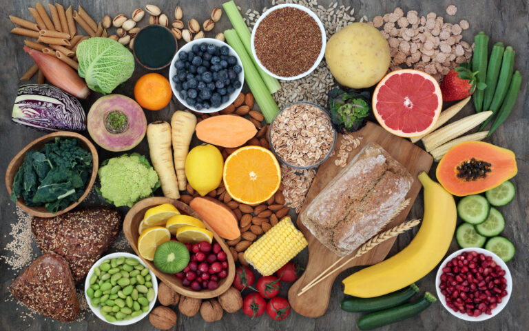 High fibre super food with whole grain bread loaf and rolls, fruit, vegetables, whole wheat pasta, cereals, seeds and nuts. Foods omega 3, anthocyanins, antioxidants and vitamins. Top view. High fibre super food with whole grain bread loaf and rolls, fruit, vegetables, whole wheat pasta, cereals, seeds and nuts. Foods omega 3, anthocyanins, antioxidants and vitamins. Top view.