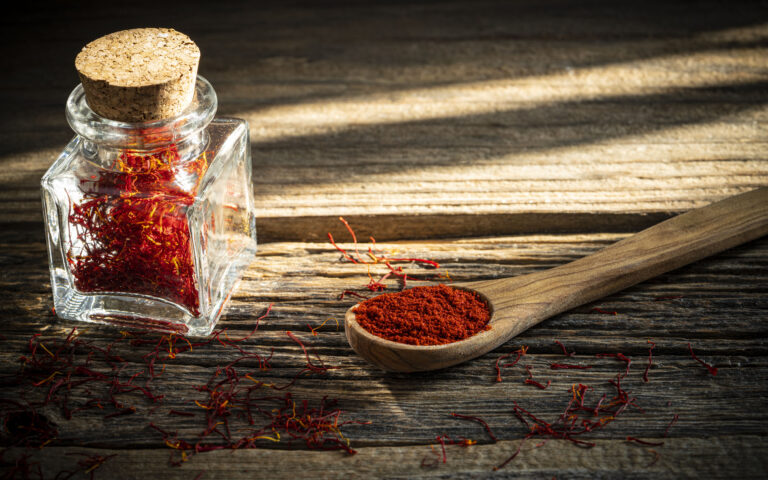 Saffron spice in glass bottle on rustic wooden table background Saffron spice in glass bottle on rustic wooden table background