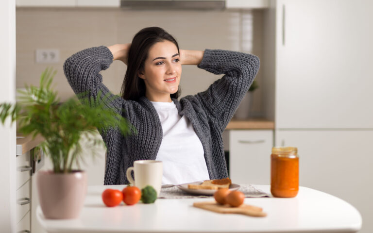 Smiling woman stretching during breakfast time in the morning Smiling woman stretching during breakfast time in the morning