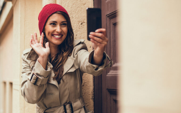 Handsome young adult women is photo messaging to her friend. She looks satisfied and happy because of lovely but cloudy Autumn day. Handsome young adult women is photo messaging to her friend. She looks satisfied and happy because of lovely but cloudy Autumn day.