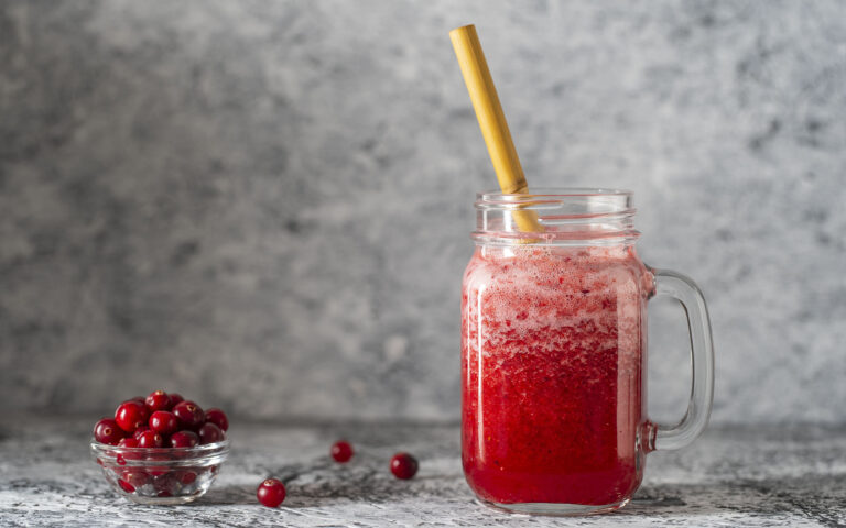 Cranberry and cowberry smoothie in mason jar with bamboo straw. Fresh organic red smoothie in glass mug on table, close up. Refreshing summer fruit drink. The concept of healthy eating. Copy space Cranberry and cowberry smoothie in mason jar with bamboo straw. Fresh organic red smoothie in glass mug on table, close up. Refreshing summer fruit drink. The concept of healthy eating. Copy space