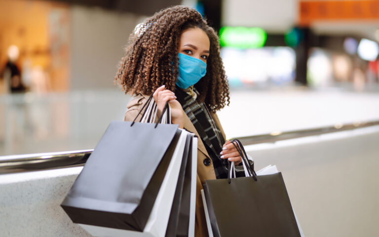 Young woman in protective medical mask make purchases in a shopping center, go shopping. Trade, buyers, black friday, discounts, sale concept. Shopping in the coronavirus epidemic. Young woman in protective medical mask make purchases in a shopping center, go shopping. Trade, buyers, black friday, discounts, sale concept. Shopping in the coronavirus epidemic.