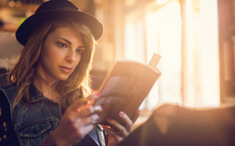 Female student reading a book while studying for her exams.
