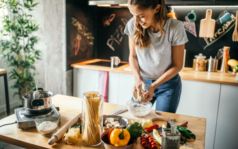 Photo of young woman preparing pizza at home Photo of young woman preparing pizza at home