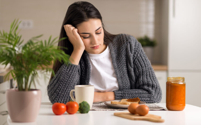 Displeased young woman doesn't want to eat her breakfast Displeased young woman doesn't want to eat her breakfast