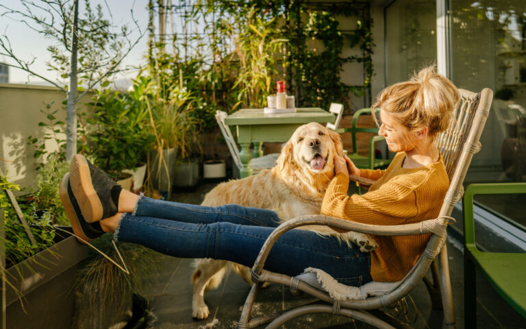 Photo of young woman and her pet enjoying together on the balcony of their loft apartment Photo of young woman and her pet enjoying together on the balcony of their loft apartment