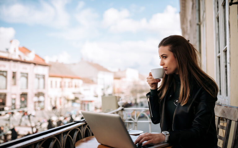 Woman drinking coffee on the terrace wihle working on a laptop. Woman drinking coffee on the terrace wihle working on a laptop.