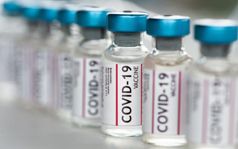 Covid-19 Coronavirus Vaccine vials in a row macro close up Covid-19 Coronavirus Vaccine vials in a row macro close up