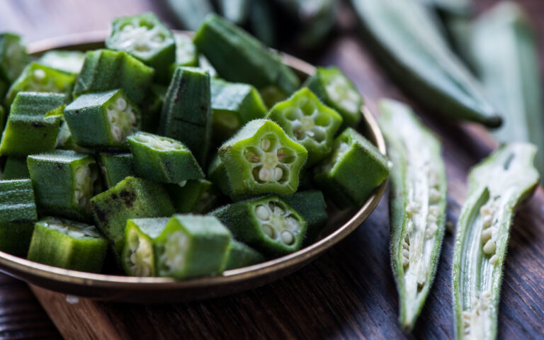Farm fresh okra on wooden board, whole and sliced Farm fresh okra on wooden board, whole and sliced