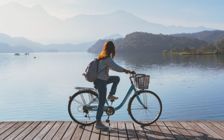 Young woman riding bicycle on Sun Moon lake bike trail, Travel lifestyle concept Young woman riding bicycle on Sun Moon lake bike trail, Travel lifestyle concept