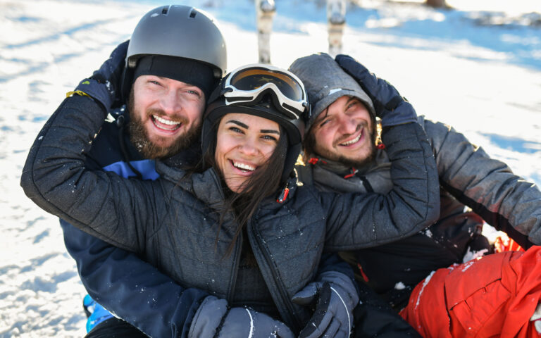 Cute Friends Embracing And Smiling During Snowy Winter Vacation