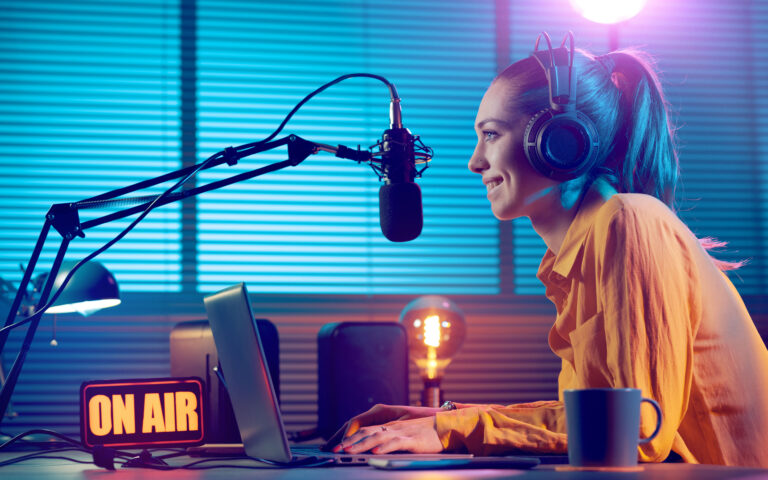 Young radio host working in the studio, she is smiling and broadcasting announcements