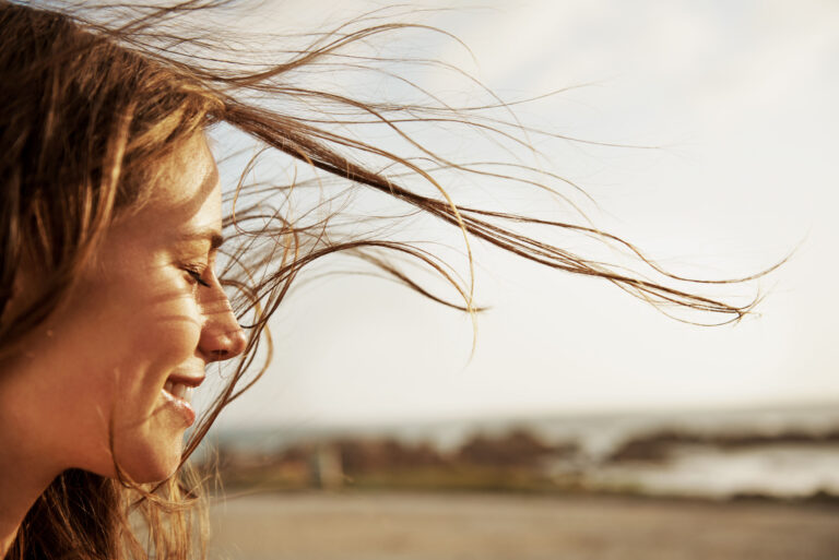 Cropped view of a young woman with the wind in her hair Cropped view of a young woman with the wind in her hair