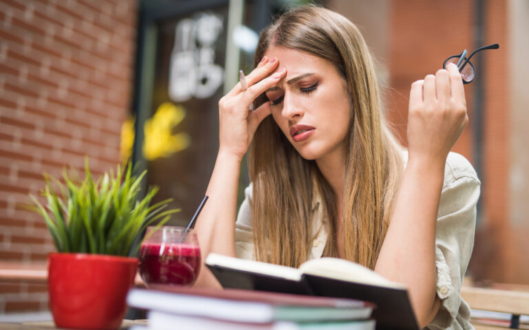 Young woman having a headache from studying.
