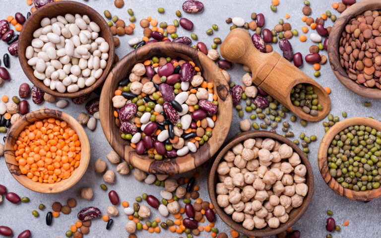 Top view of different beans, lentils, mung, chickpeas in wooden bowls for tasty meals on grey concrete background Top view of different beans, lentils, mung, chickpeas in wooden bowls for tasty meals on grey concrete background