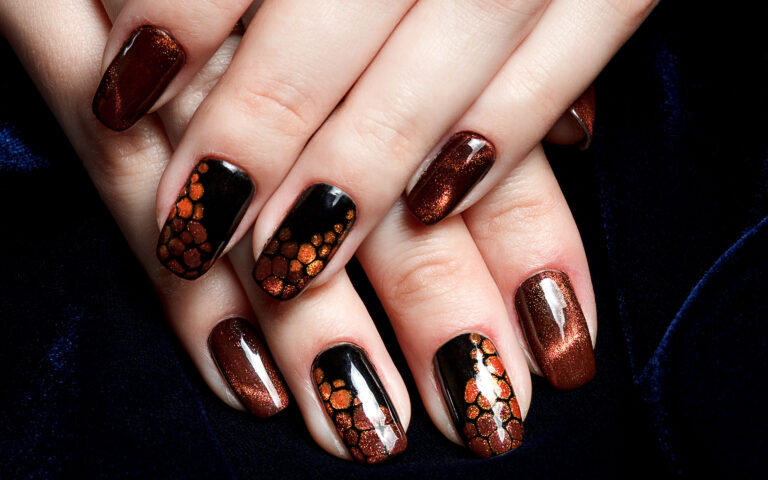 French manicure - beautiful manicured female hands with brown "cat eye" manicure on dark background, panoramic banner