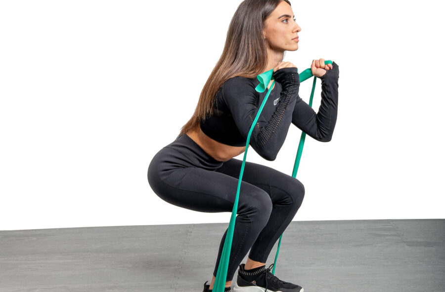 Gambe e spalle: per aumentare il tono fai gli squat con la banda elastica