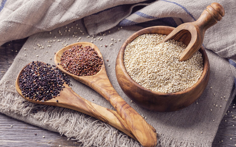 Red, black and white quinoa seeds on a white background