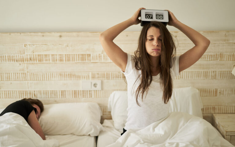 woman in bed with burnout and vintage flip clock on her head woman in bed with burnout and vintage flip clock on her head