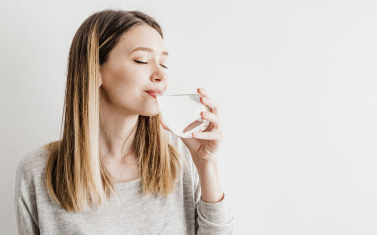 Young woman drinking water and smiling