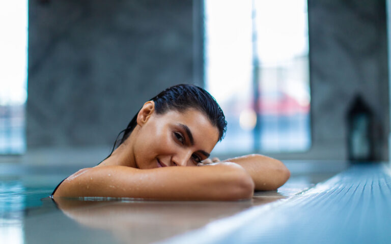 Portrait of beautiful woman relaxing and enjoying in swimming pool at morning. Photo taken under available light Portrait of beautiful woman relaxing and enjoying in swimming pool at morning. Photo taken under available light