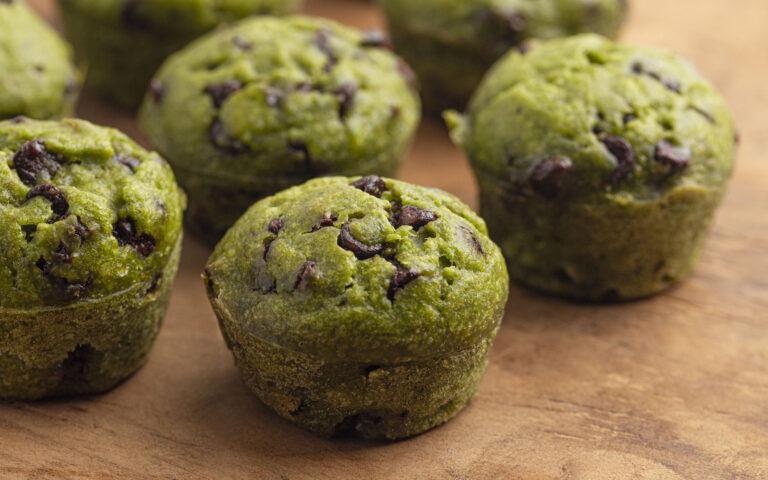 Healthy Green Spinach Chocolate Chip Mini Muffins on a Wooden Table Healthy Green Spinach Chocolate Chip Mini Muffins on a Wooden Table