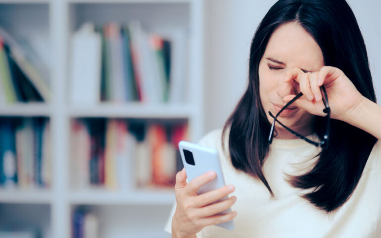 Woman Checking Smartphone Rubbing her Dry Eyes Woman Checking Smartphone Rubbing her Dry Eyes